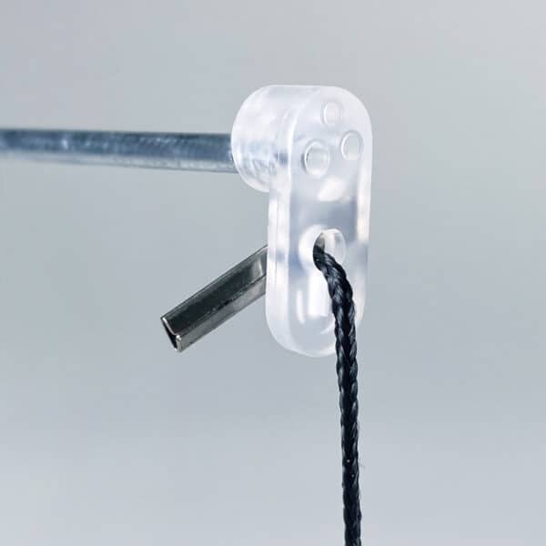A close up view of a mobile wire and plastic end cap, supporting a hanging string.