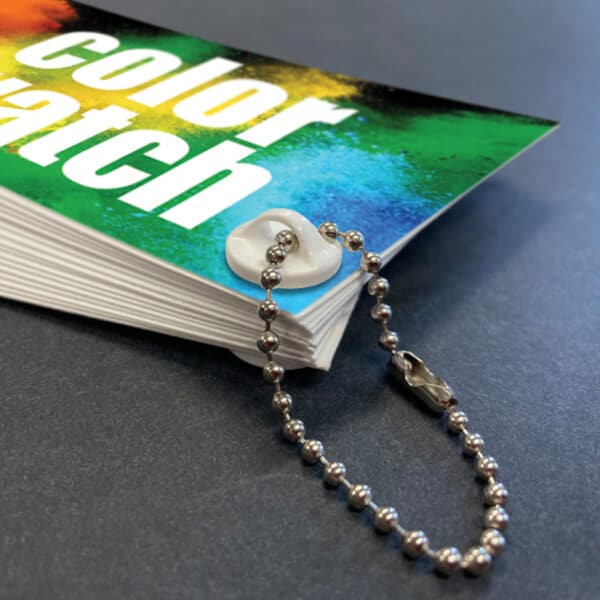 A color swatch book, loop screw and loop of beaded chain.