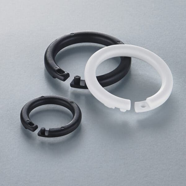 Three plastic snap-rings in black and white.