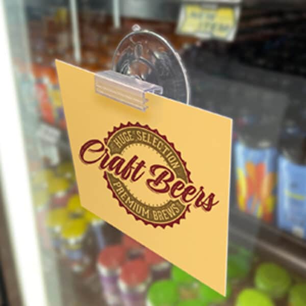 A suction cup with sign holder holds a small sign on a glass bakery display.