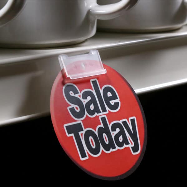 A small "on-sale" sign held in a store shelf channel with a Popco self-piercing sign holder.