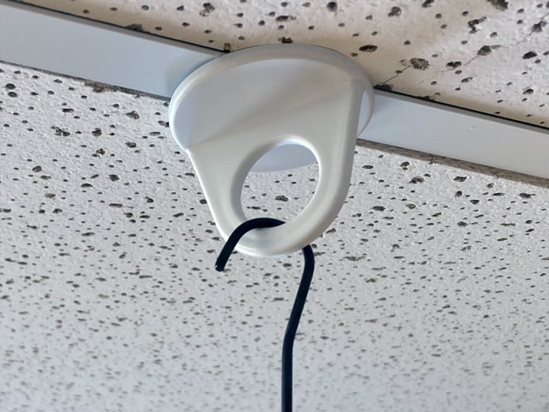 A Popco ceiling twist clip and wire hook for sign hanging.
