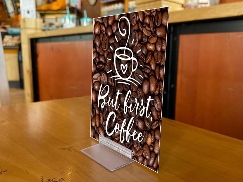 A Popco sign base shown supporting a small sign in a coffee shop.